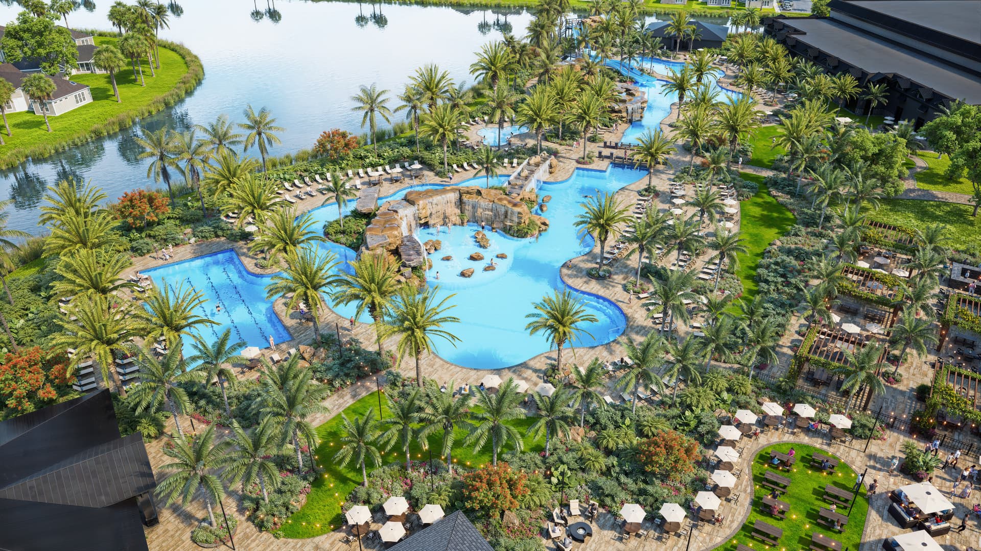 Aerial view of the resort-style lagoon pool, palms and clubhouse at Kingston South in Estero, Florida
